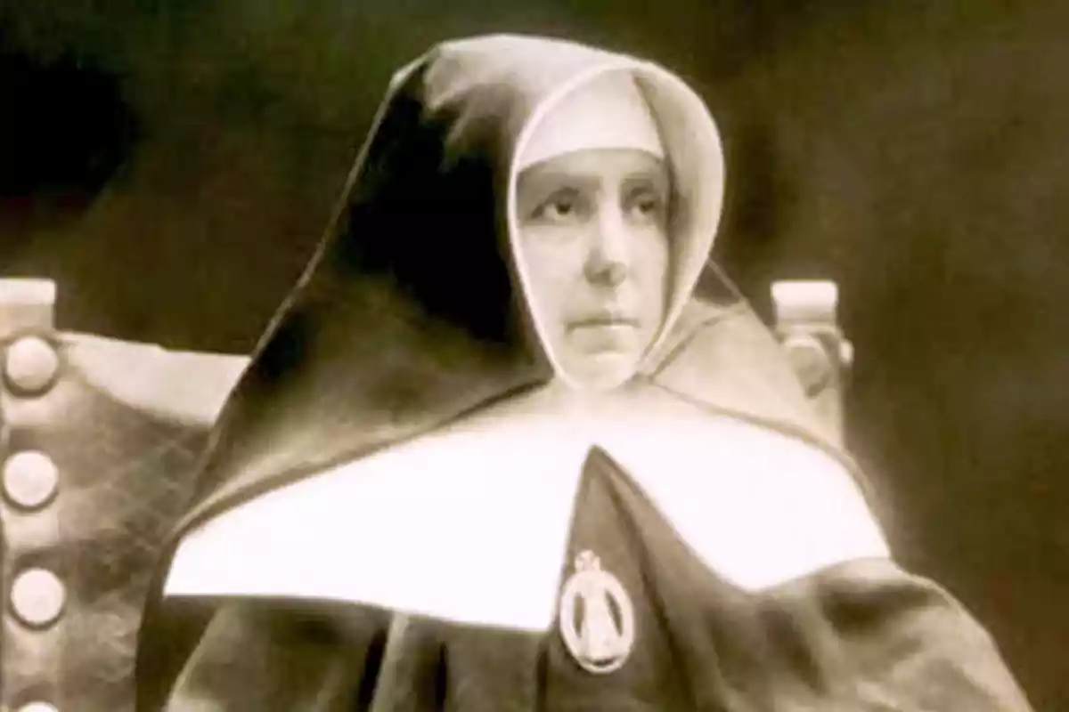 Mujer vestida con hábito religioso antiguo sentada y mirando hacia el frente Mujer vestida con hábito religioso antiguo sentada y mirando hacia el frente