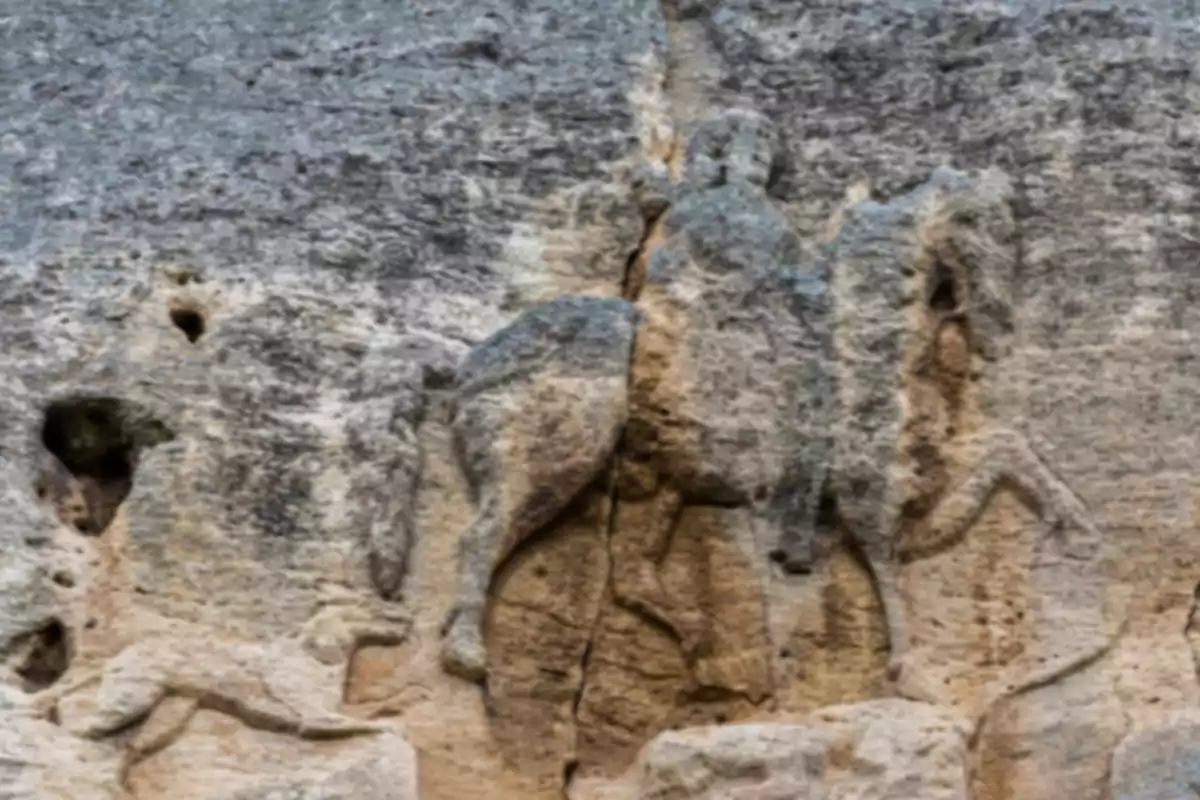 Antic relleu esculpit en pedra que mostra una figura muntant un cavall al costat d'altres animals Antic relleu esculpit en pedra que mostra una figura muntant un cavall al costat d'altres animals