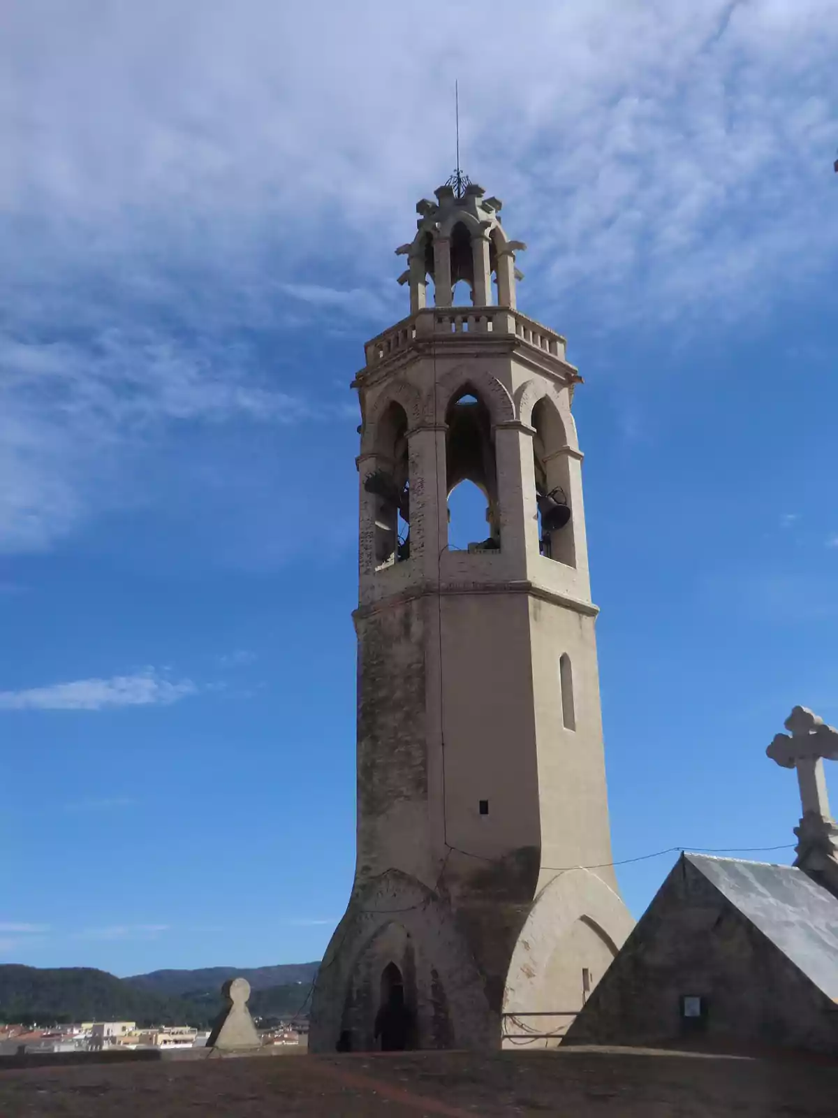 Campanario antiguo de piedra con cielo azul y algunas nubes de fondo Campanario antiguo de piedra con cielo azul y algunas nubes de fondo