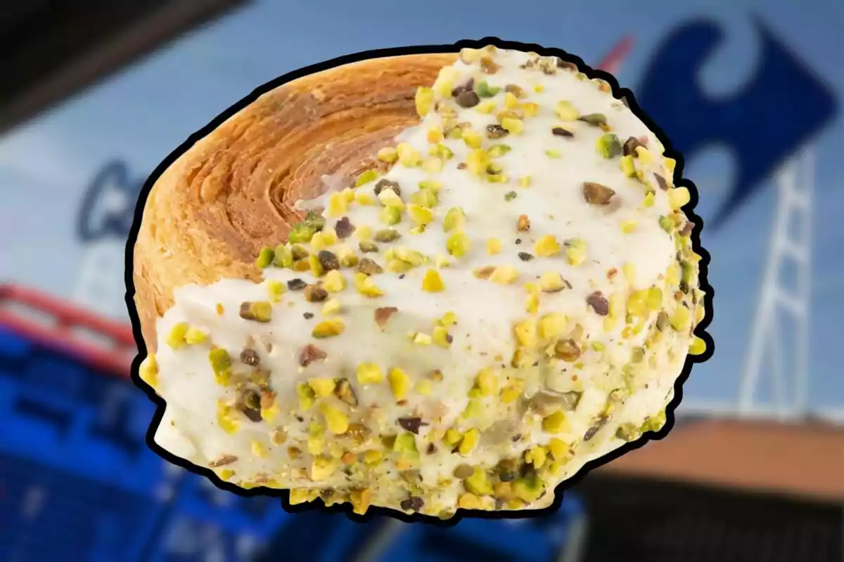 Un pan de hojaldre cubierto con glaseado blanco y trozos de pistache frente a un fondo borroso de supermercado. Un pan de hojaldre cubierto con glaseado blanco y trozos de pistache frente a un fondo borroso de supermercado.
