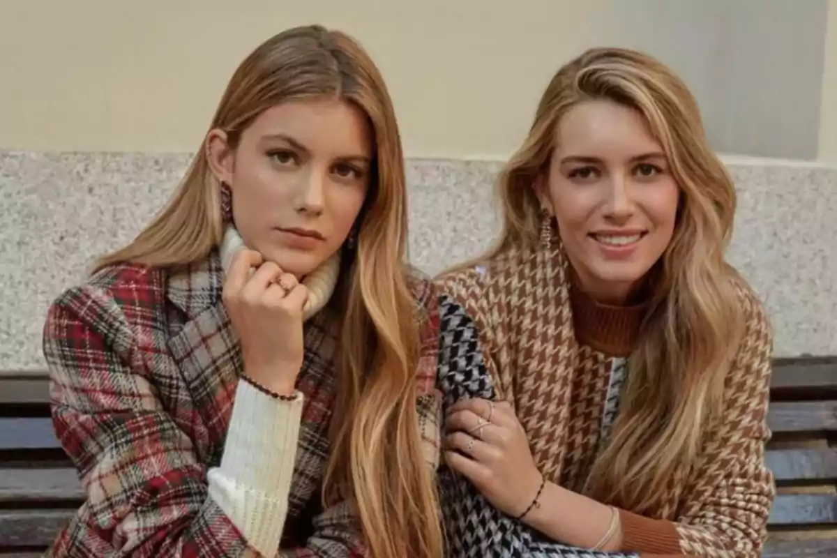 Martina and Daniela Figo Svedin, with long blonde hair, are sitting on a bench; both are wearing plaid coats and looking at the camera, one of them is smiling while the other has a serious expression. Martina and Daniela Figo Svedin, with long blonde hair, are sitting on a bench; both are wearing plaid coats and looking at the camera, one of them is smiling while the other has a serious expression.