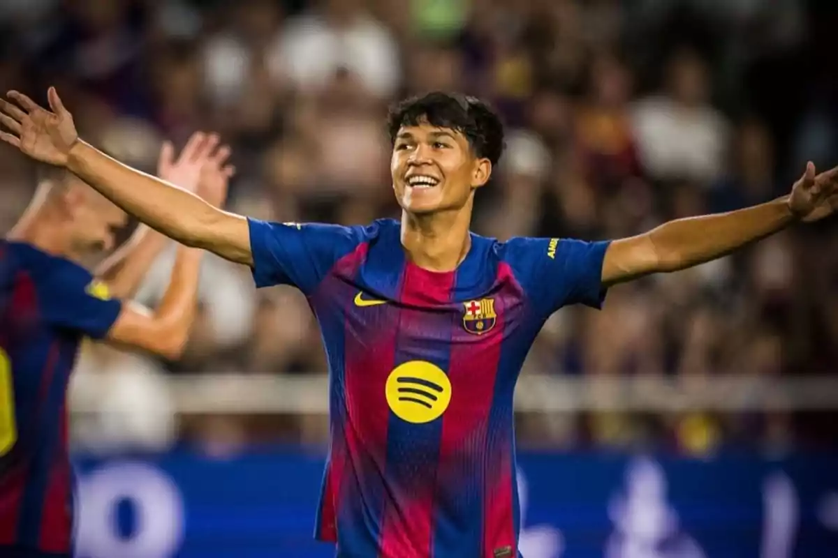 Barcelona player celebrating a goal with arms outstretched and a big smile on his face during a match Barcelona player celebrating a goal with arms outstretched and a big smile on his face during a match