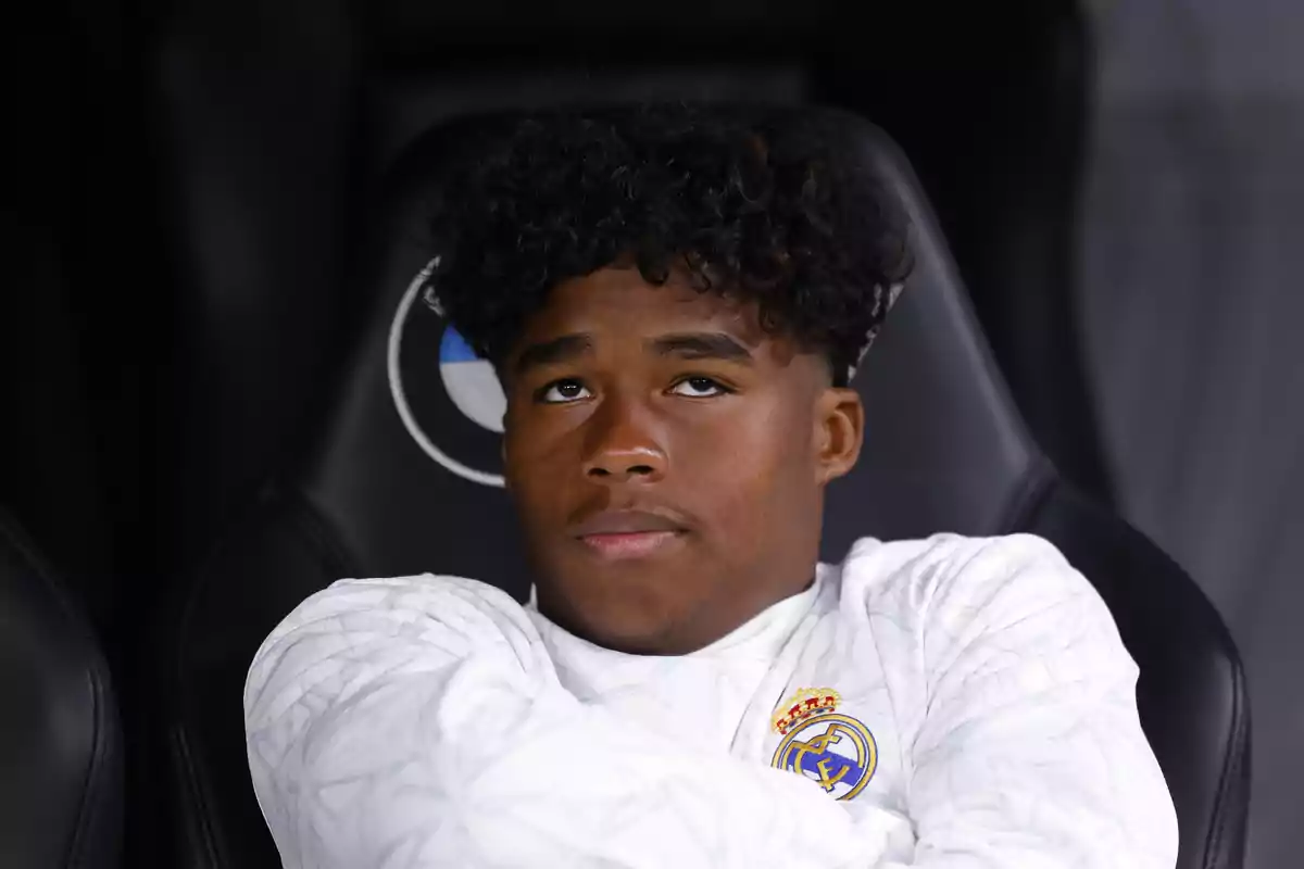 Endrick con chaqueta blanca del Real Madrid sentado en el banquillo con expresión pensativa Endrick con chaqueta blanca del Real Madrid sentado en el banquillo con expresión pensativa