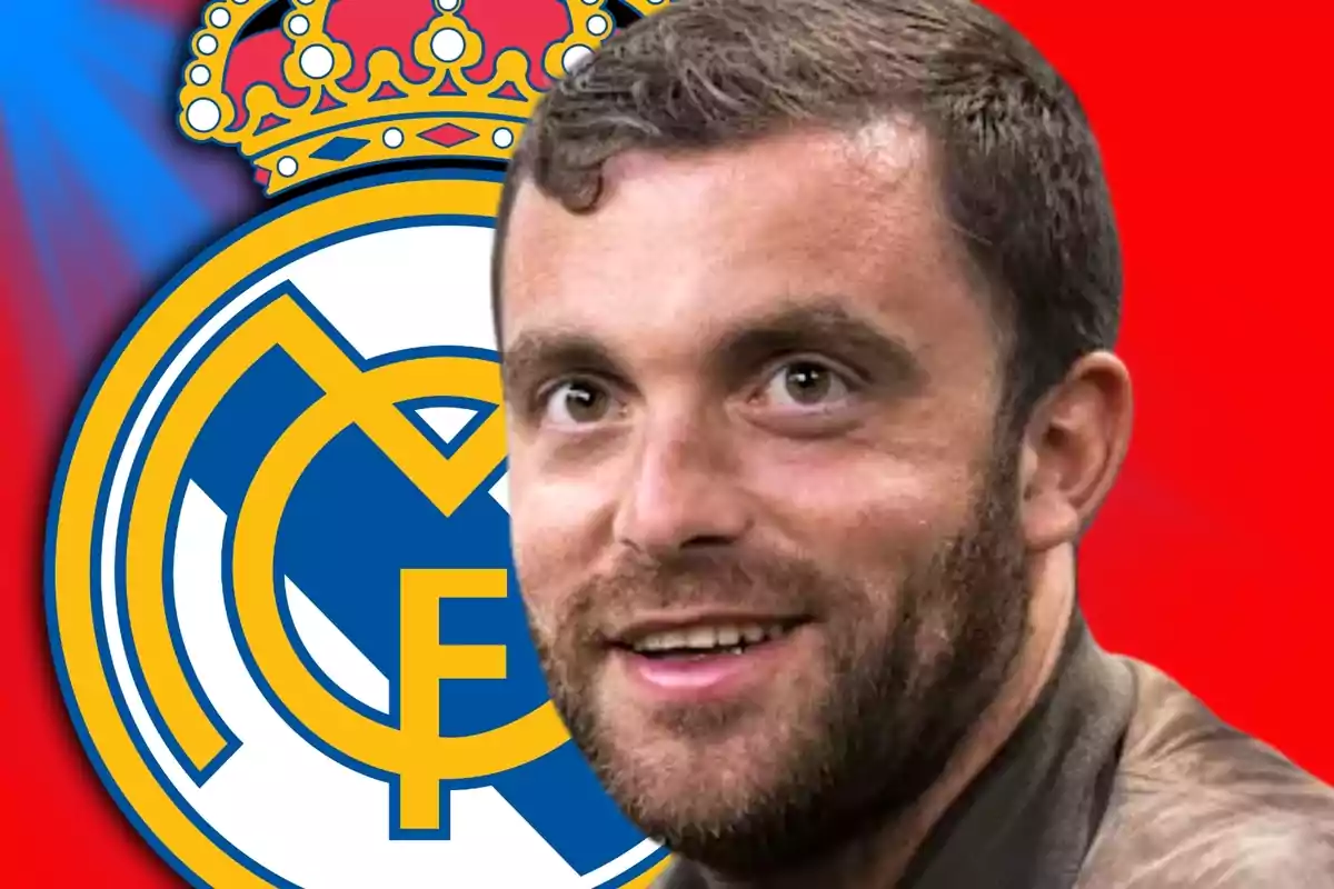 Smiling man in the foreground with the Real Madrid crest in the background against a red backdrop.