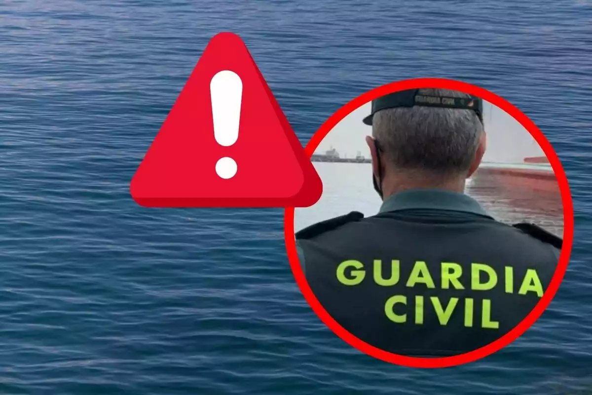 Un agente de la Guardia Civil de espaldas junto al mar con un símbolo de advertencia en primer plano