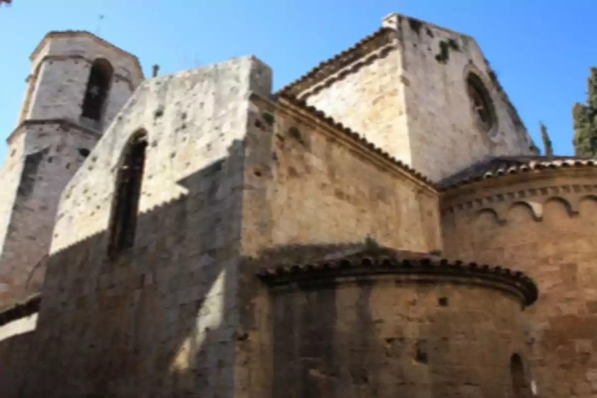 Edifici antic de pedra amb parets i torre sota un cel blau Edifici antic de pedra amb parets i torre sota un cel blau