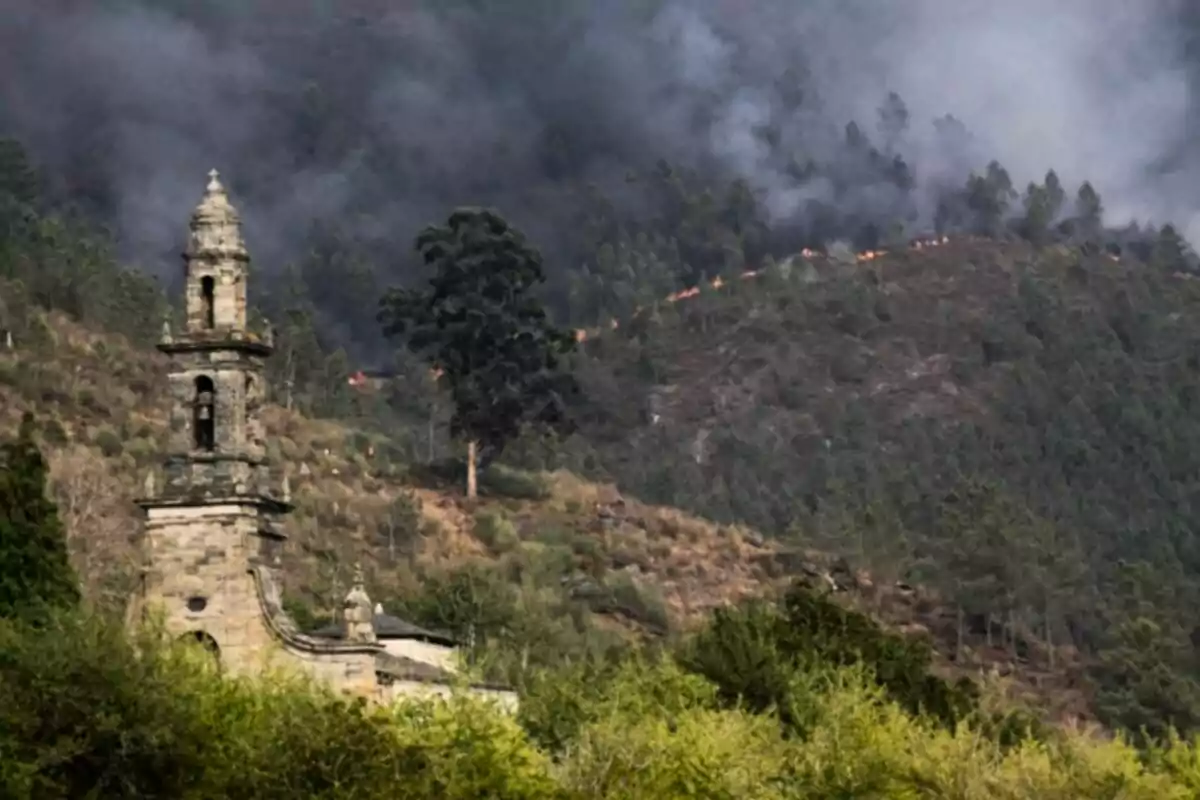 Imagen de una iglesia en primer plano con una montaña afectada por un incendio detrás Imagen de una iglesia en primer plano con una montaña afectada por un incendio detrás