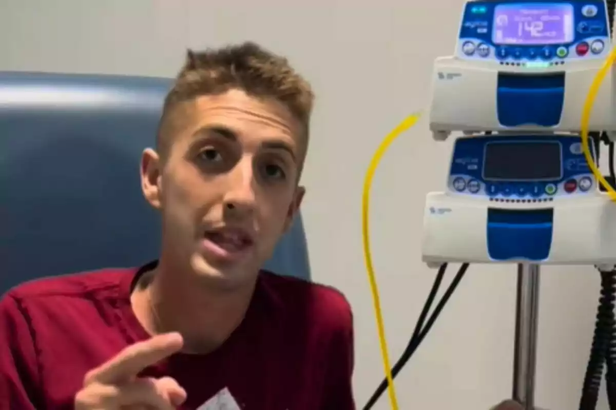 Joven sentado en una silla de hospital junto a un equipo de infusión médica con tubos amarillos. Joven sentado en una silla de hospital junto a un equipo de infusión médica con tubos amarillos.