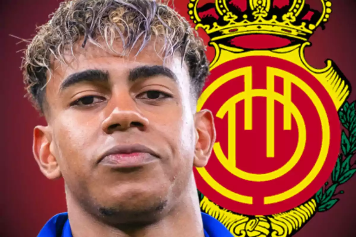 Joven con cabello rizado y teñido al frente de un escudo del club de fútbol Mallorca