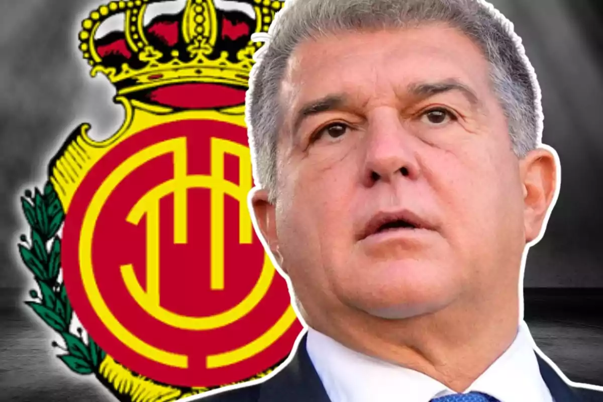 Home amb vestit i expressió seriosa davant l’escut del club de futbol Mallorca