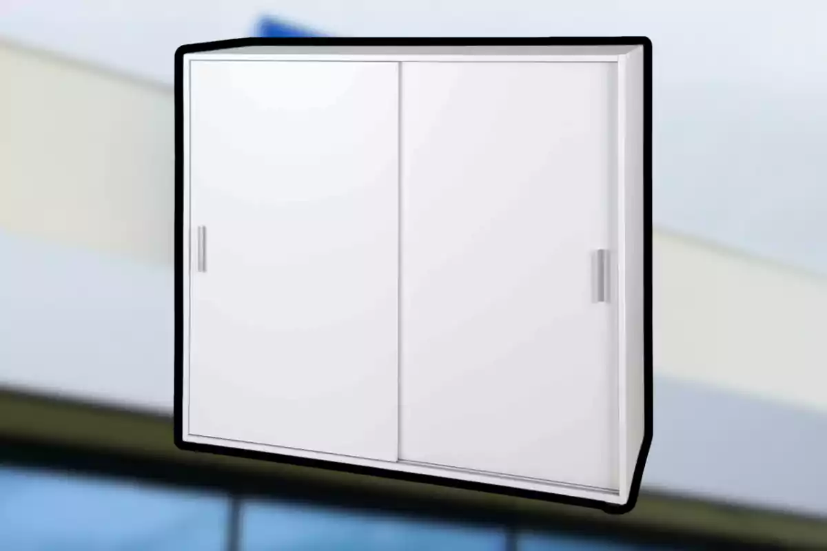 White wall cabinet with sliding doors and rectangular handles against a blurred background. White wall cabinet with sliding doors and rectangular handles against a blurred background.