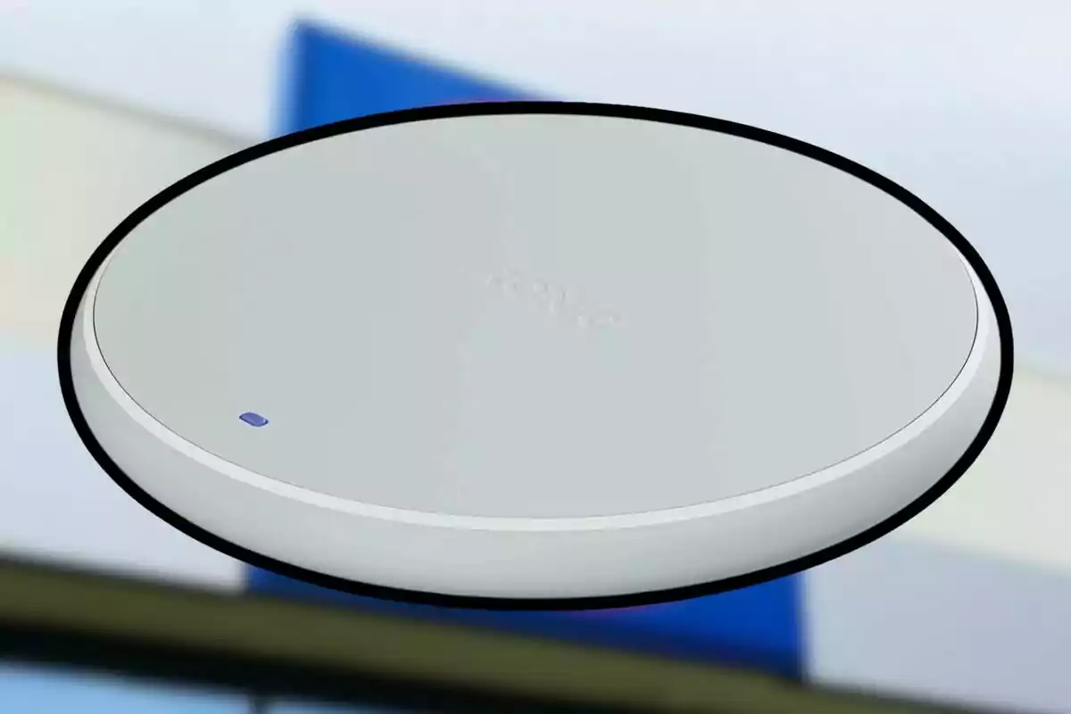 Dispositivo circular blanco con un pequeño indicador azul sobre un fondo desenfocado. Dispositivo circular blanco con un pequeño indicador azul sobre un fondo desenfocado.
