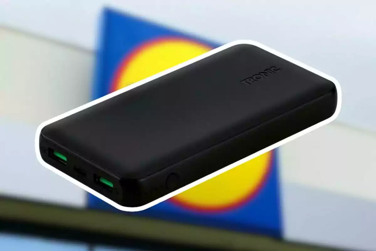 Bateria externa negra de la marca Tronic amb dos ports USB i un fons desenfocat d’un logotip de supermercat. Bateria externa negra de la marca Tronic amb dos ports USB i un fons desenfocat d’un logotip de supermercat.