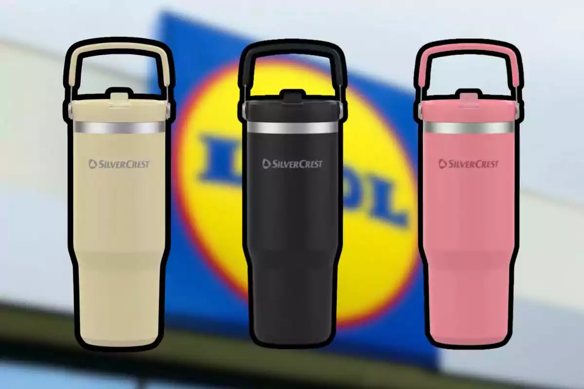 Three SilverCrest thermoses in beige, black, and pink with a lid and handle, in front of a blurry Lidl store sign. Three SilverCrest thermoses in beige, black, and pink with a lid and handle, in front of a blurry Lidl store sign.