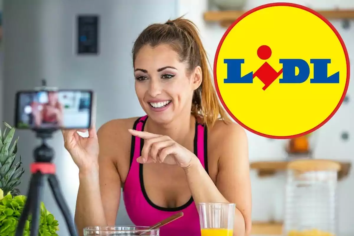 Smiling woman recording a video in the kitchen with a glass of juice and the Lidl logo in the background
