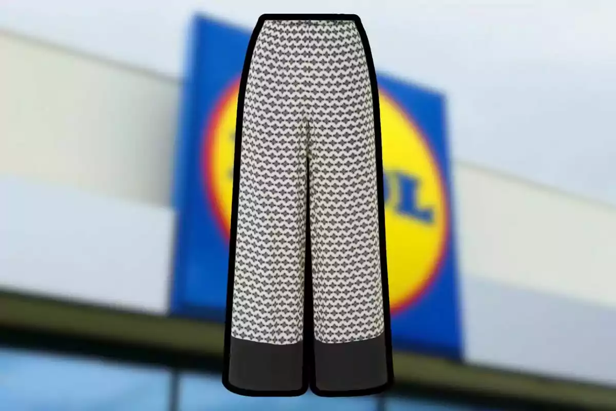 Wide-leg pants with a black and white geometric print and black detail at the hem in front of a store Wide-leg pants with a black and white geometric print and black detail at the hem in front of a store