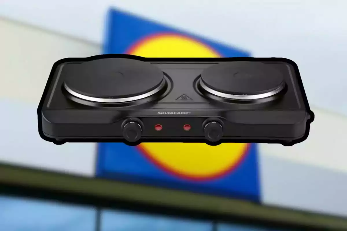 Cuina elèctrica de dos fogons de la marca SilverCrest amb un fons desenfocat d’un rètol de supermercat Cuina elèctrica de dos fogons de la marca SilverCrest amb un fons desenfocat d’un rètol de supermercat