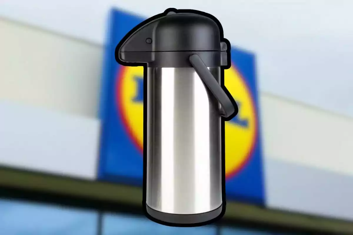 Stainless steel dispenser thermos with black lid and handle in front of a blurry store sign Stainless steel dispenser thermos with black lid and handle in front of a blurry store sign
