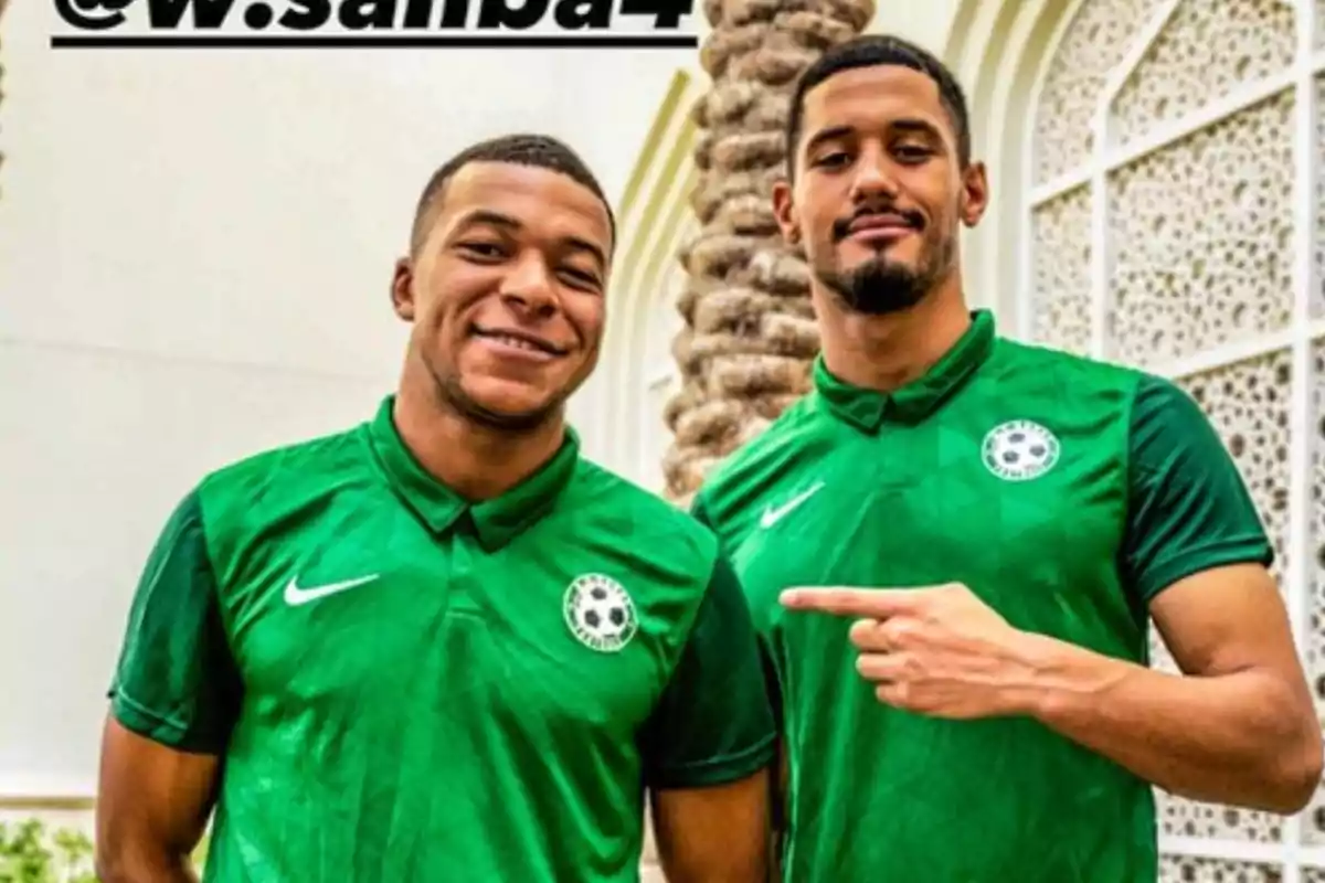 Dos hombres con camisetas verdes de fútbol posan sonrientes frente a una palmera y una pared decorada Dos hombres con camisetas verdes de fútbol posan sonrientes frente a una palmera y una pared decorada