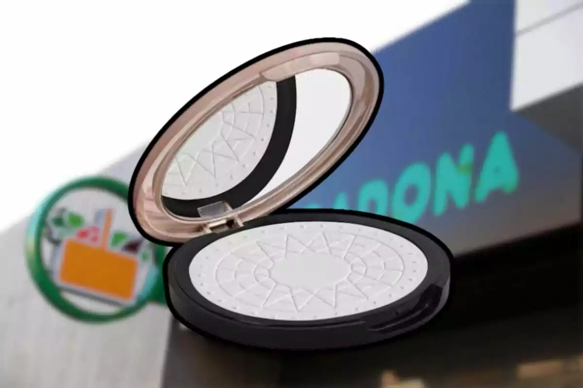 Polvo compacto de maquillaje con espejo en primer plano y un supermercado de fondo desenfocado Polvo compacto de maquillaje con espejo en primer plano y un supermercado de fondo desenfocado