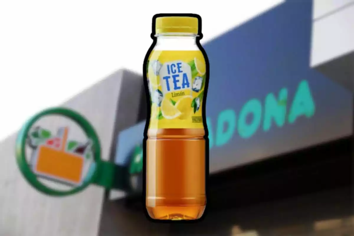 Botella de té helado sabor limón frente a una tienda Mercadona desenfocada Botella de té helado sabor limón frente a una tienda Mercadona desenfocada
