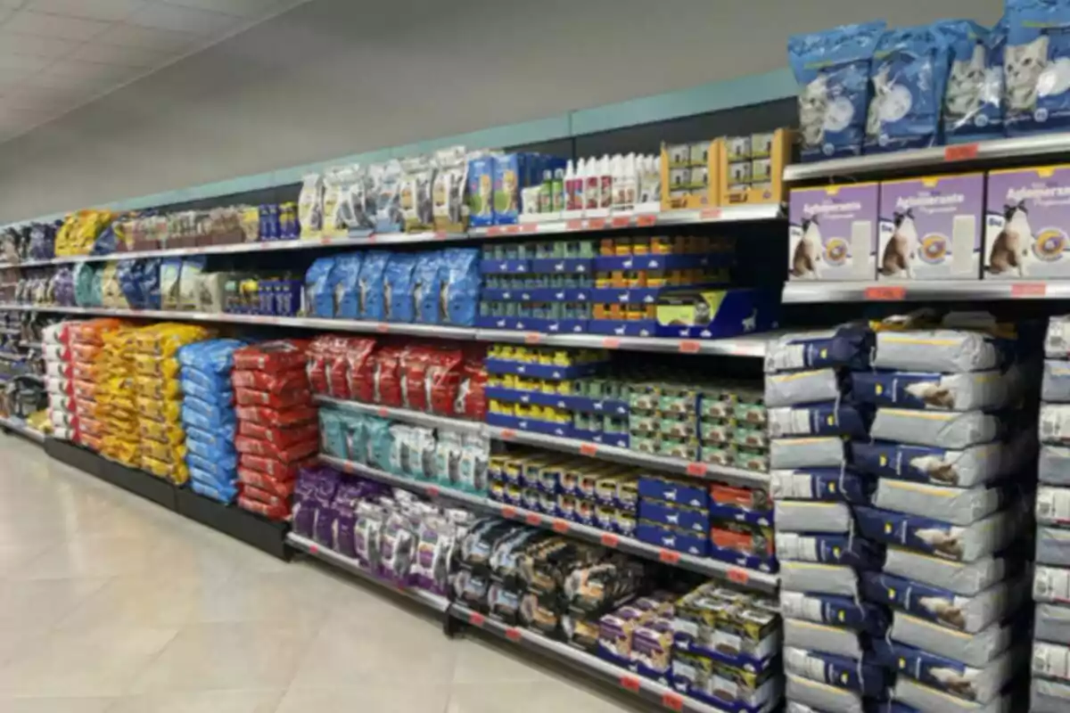 Estante de supermercado lleno de bolsas y cajas de alimento para mascotas organizadas por colores y tamaños Estante de supermercado lleno de bolsas y cajas de alimento para mascotas organizadas por colores y tamaños