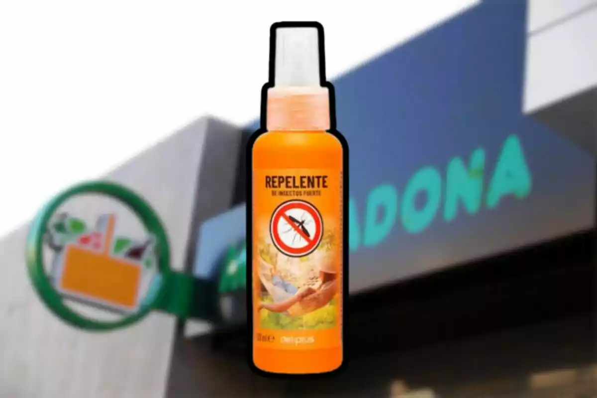 Un frasco de repelente de insectos Deliplus en primer plano con una tienda Mercadona desenfocada al fondo Un frasco de repelente de insectos Deliplus en primer plano con una tienda Mercadona desenfocada al fondo