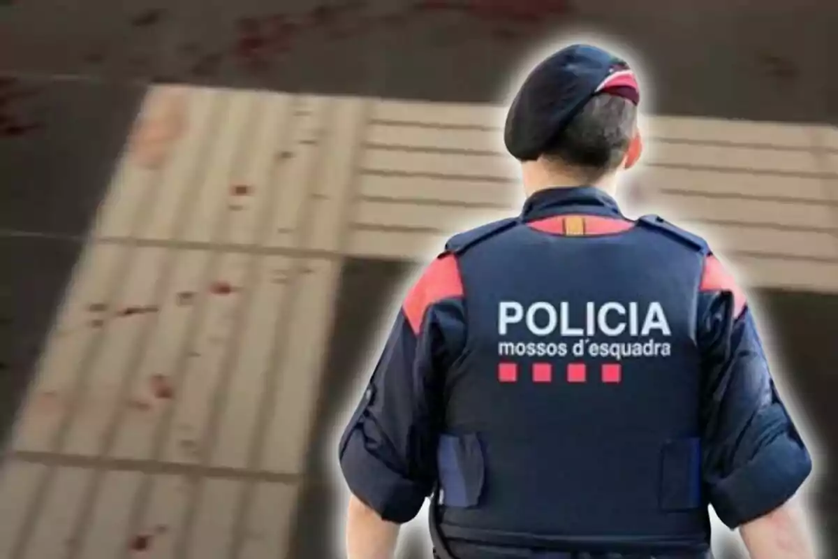 Agente de los Mossos d'Esquadra de espaldas en una escena urbana con manchas en el suelo
