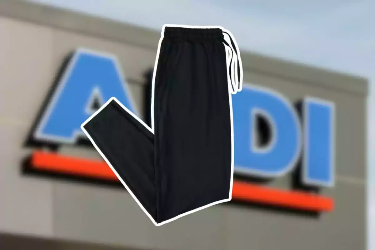 Unos pantalones deportivos negros con cordón blanco aparecen sobre el fondo de una tienda Aldi desenfocada. Unos pantalones deportivos negros con cordón blanco aparecen sobre el fondo de una tienda Aldi desenfocada.