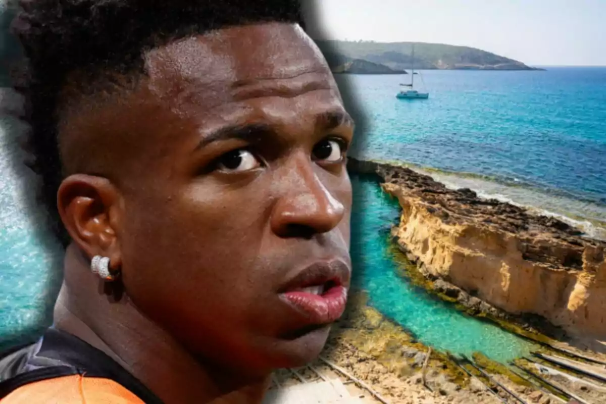 Close-up of Vinicius with a serious expression against a beach background with blue sea and a boat in the distance
