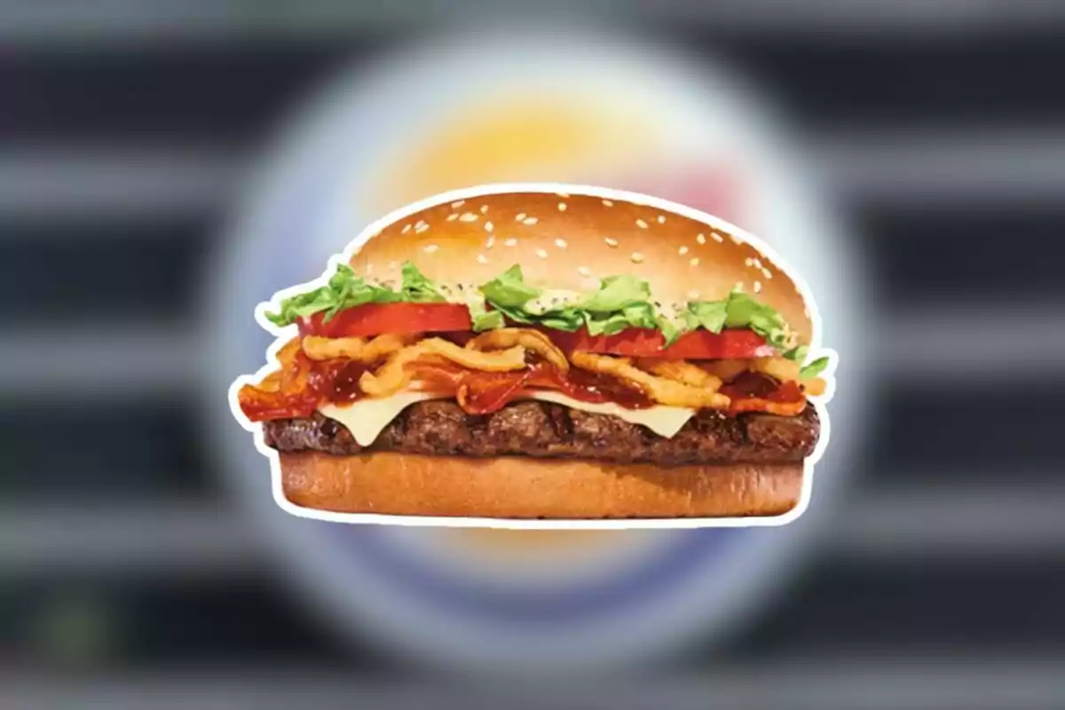 Burger with beef, cheese, bacon, onion rings, lettuce, and tomato on a sesame seed bun Burger with beef, cheese, bacon, onion rings, lettuce, and tomato on a sesame seed bun