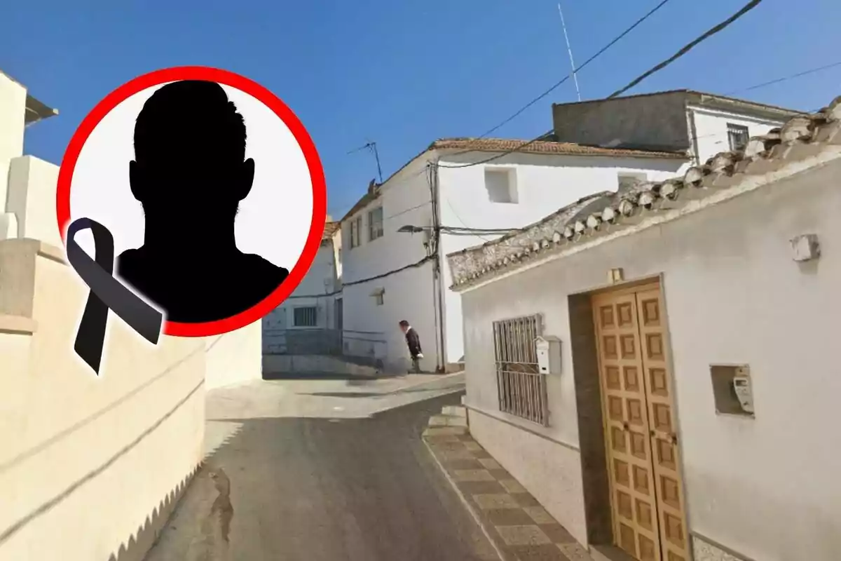 Carrer d’un poble de Granada amb cases blanques i un cercle amb la silueta d’una persona i un llaç negre en senyal de dol.