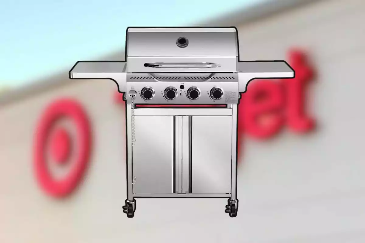 Parrilla de gas plateada con cuatro perillas frente a un fondo desenfocado de una tienda Parrilla de gas plateada con cuatro perillas frente a un fondo desenfocado de una tienda