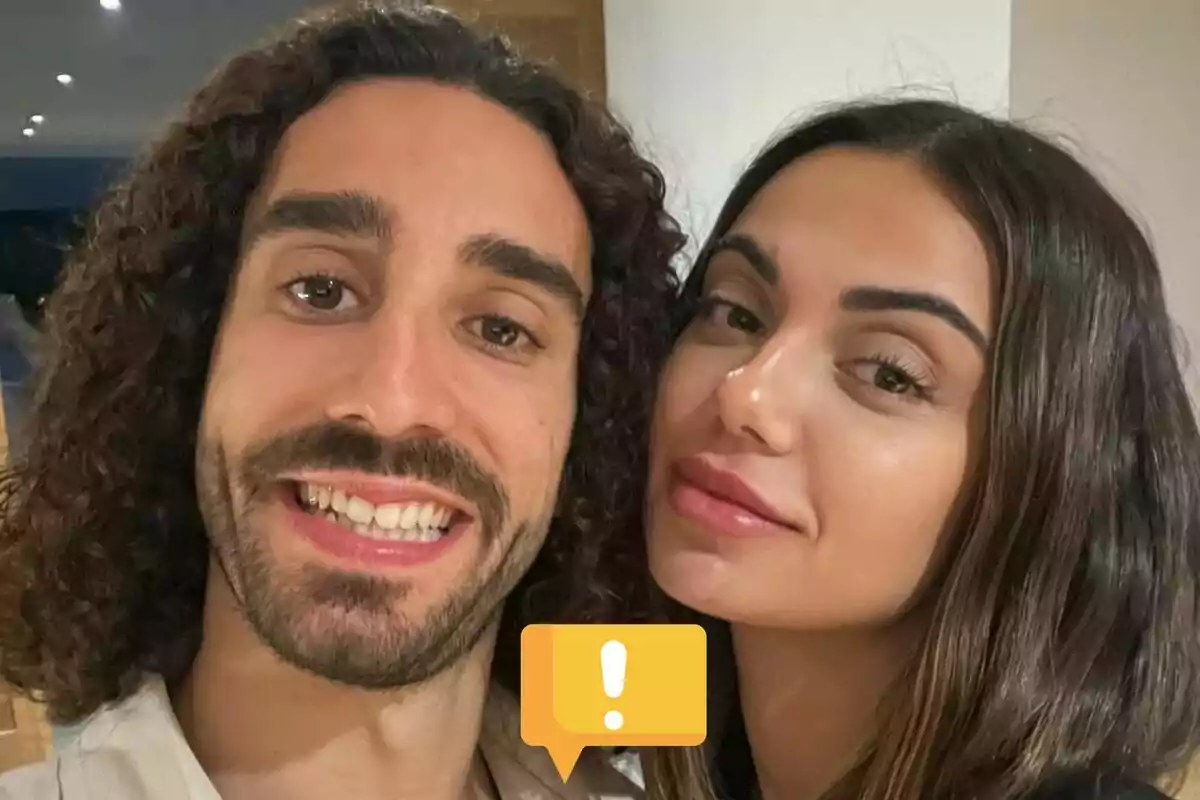 Marc Cucurella i Claudia Rodríguez posant per a una selfie en interiors amb una icona d’advertència groga a la part inferior de la imatge