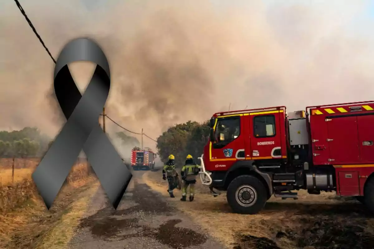 Camión de bomberos y dos bomberos combatiendo un incendio forestal con un lazo negro de luto en primer plano