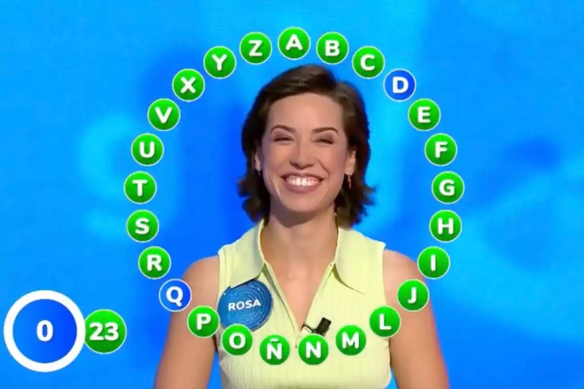 Rosa sonriente en un concurso de televisión con letras del abecedario rodeándola y un marcador de tiempo a la izquierda. Captura de 'Pasapalabra' Rosa sonriente en un concurso de televisión con letras del abecedario rodeándola y un marcador de tiempo a la izquierda. Captura de 'Pasapalabra'