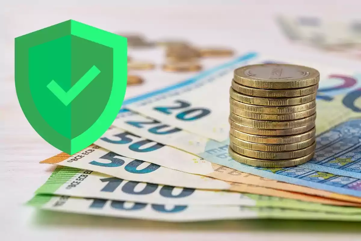 Monedes apilades i bitllets d’euro amb un escut verd de seguretat al davant Monedes apilades i bitllets d’euro amb un escut verd de seguretat al davant