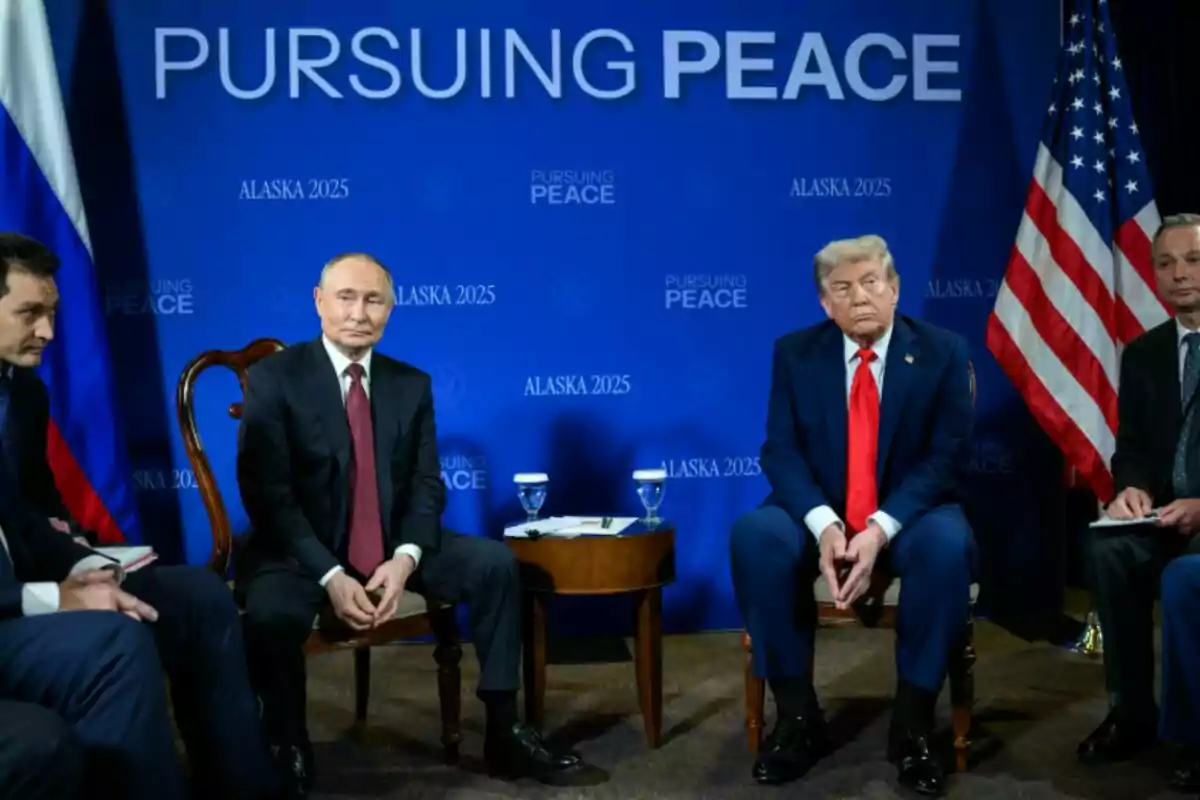 Donald Trump i Vladímir Putin amb vestits formals asseguts davant d’un fons blau amb les paraules Pursuing Peace i banderes de Rússia i dels Estats Units als costats Donald Trump i Vladímir Putin amb vestits formals asseguts davant d’un fons blau amb les paraules Pursuing Peace i banderes de Rússia i dels Estats Units als costats