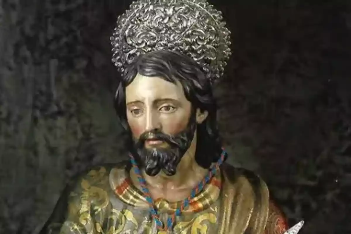 Escultura religiosa d’un home amb barba, cabells foscos i una aurèola platejada sobre el cap, vestit amb una túnica decorada