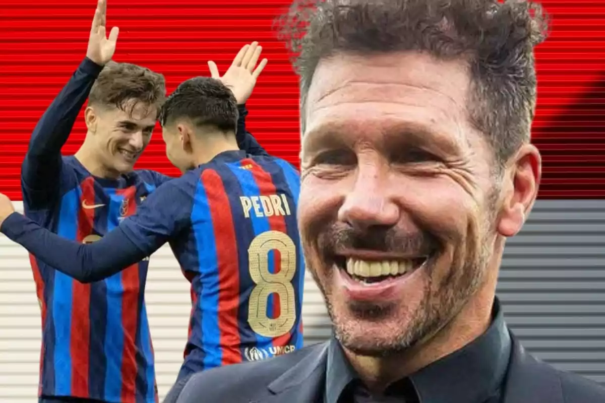 Dos futbolistas con uniforme azul y rojo celebran mientras un hombre sonriente aparece en primer plano sobre un fondo de líneas rojas y grises