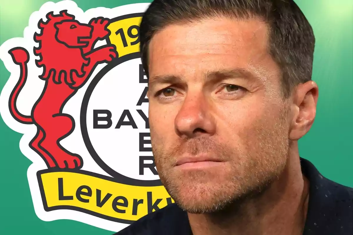 Hombre de cabello corto y barba recortada con expresión seria frente al escudo del Bayer Leverkusen
