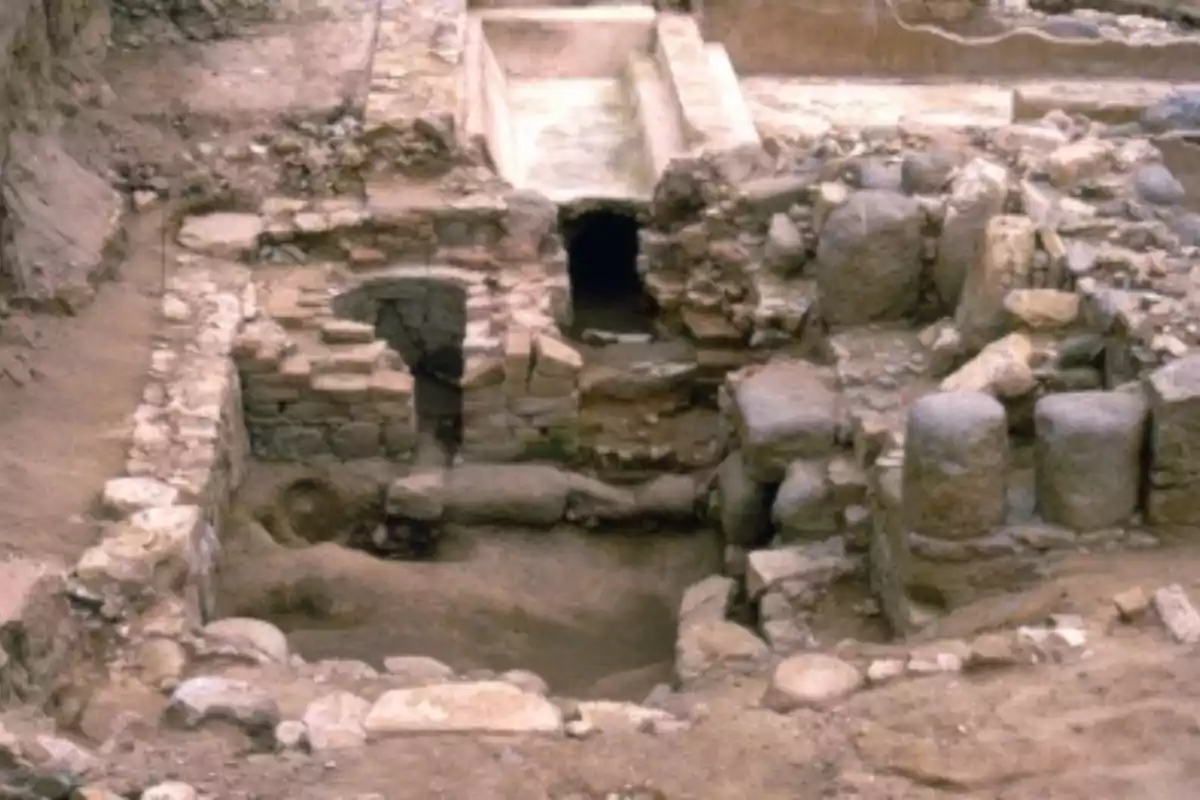 Ruinas arqueológicas con estructuras de piedra y ladrillo parcialmente enterradas en la tierra Ruinas arqueológicas con estructuras de piedra y ladrillo parcialmente enterradas en la tierra