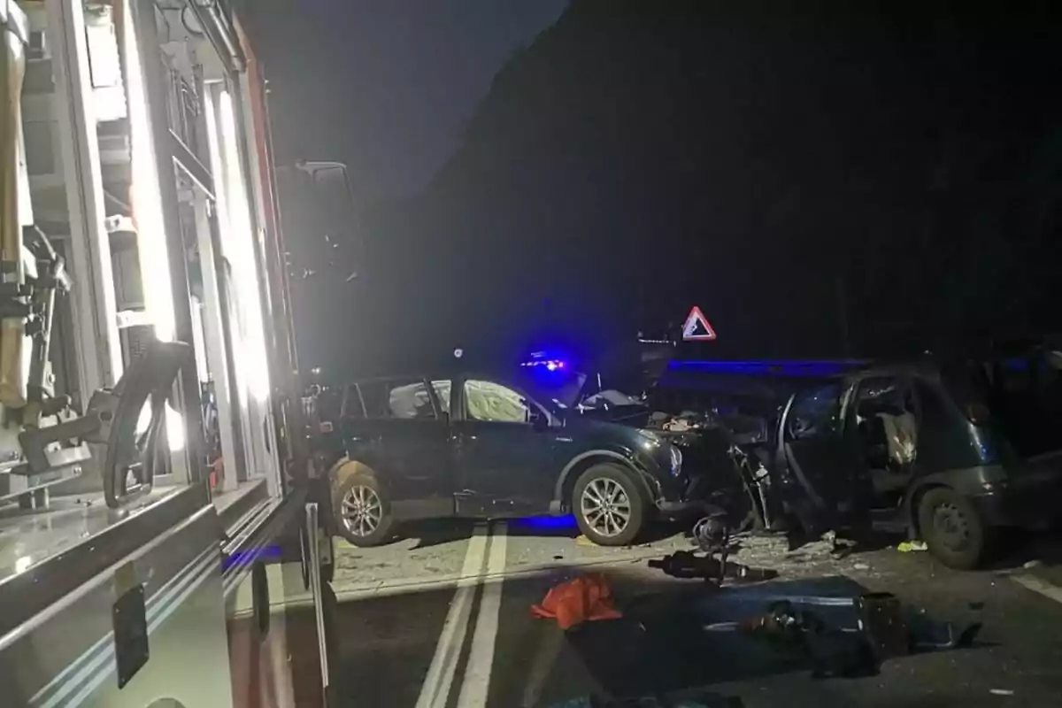 Accident automobilístic nocturn amb dos vehicles greument danyats i presència d’un camió de bombers il·luminant l’escena Accident automobilístic nocturn amb dos vehicles greument danyats i presència d’un camió de bombers il·luminant l’escena