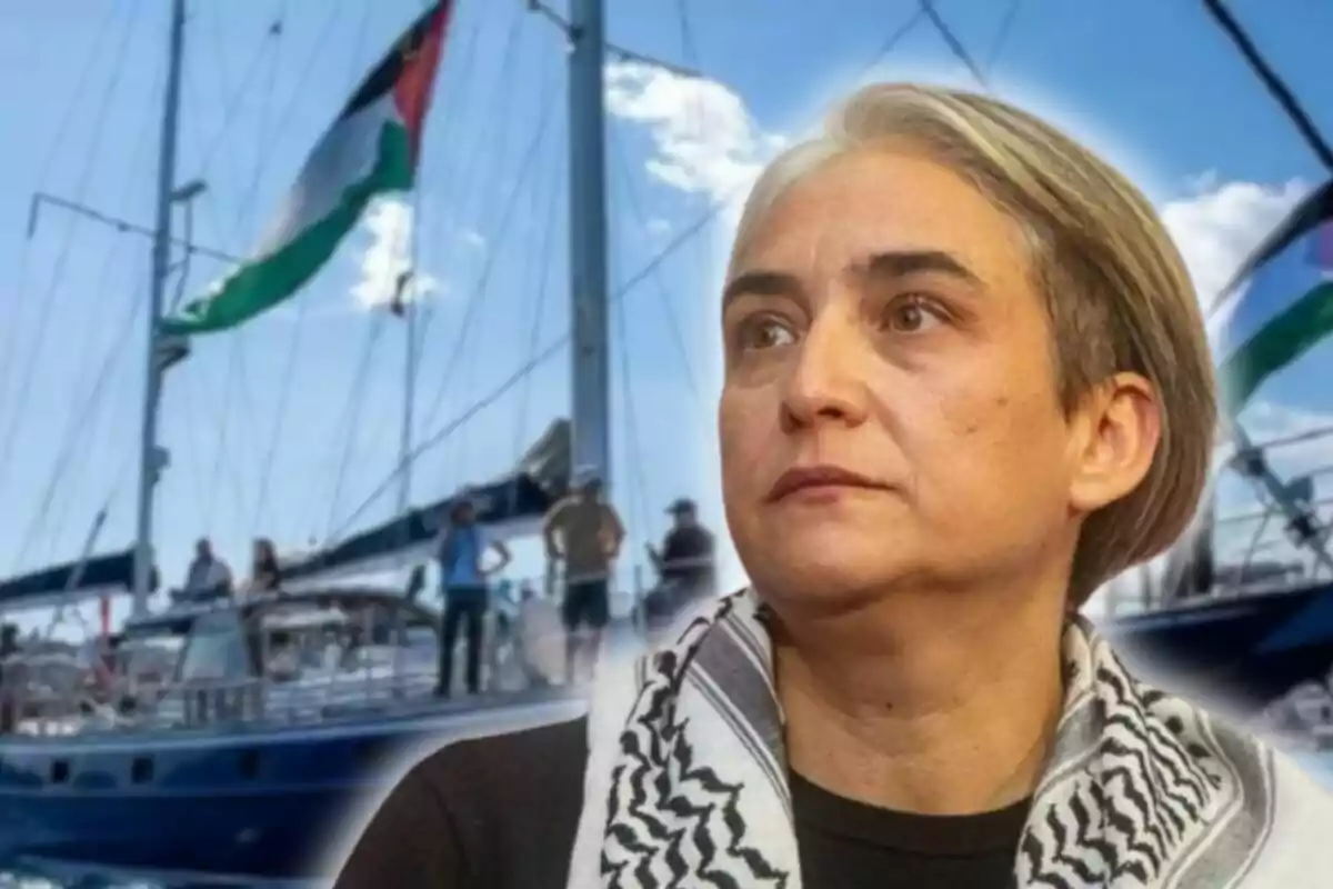 Mujer de cabello corto con pañuelo blanco y negro al cuello en primer plano, al fondo un barco con varias personas y una bandera ondeando.