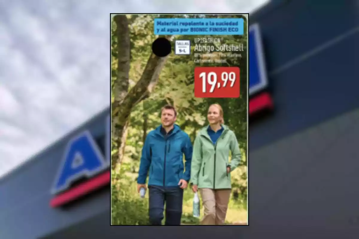 Parella caminant per un bosc amb jaquetes tipus softshell amb un preu destacat de 19,99 euros i text promocional sobre material repel·lent a la brutícia i a l’aigua Parella caminant per un bosc amb jaquetes tipus softshell amb un preu destacat de 19,99 euros i text promocional sobre material repel·lent a la brutícia i a l’aigua