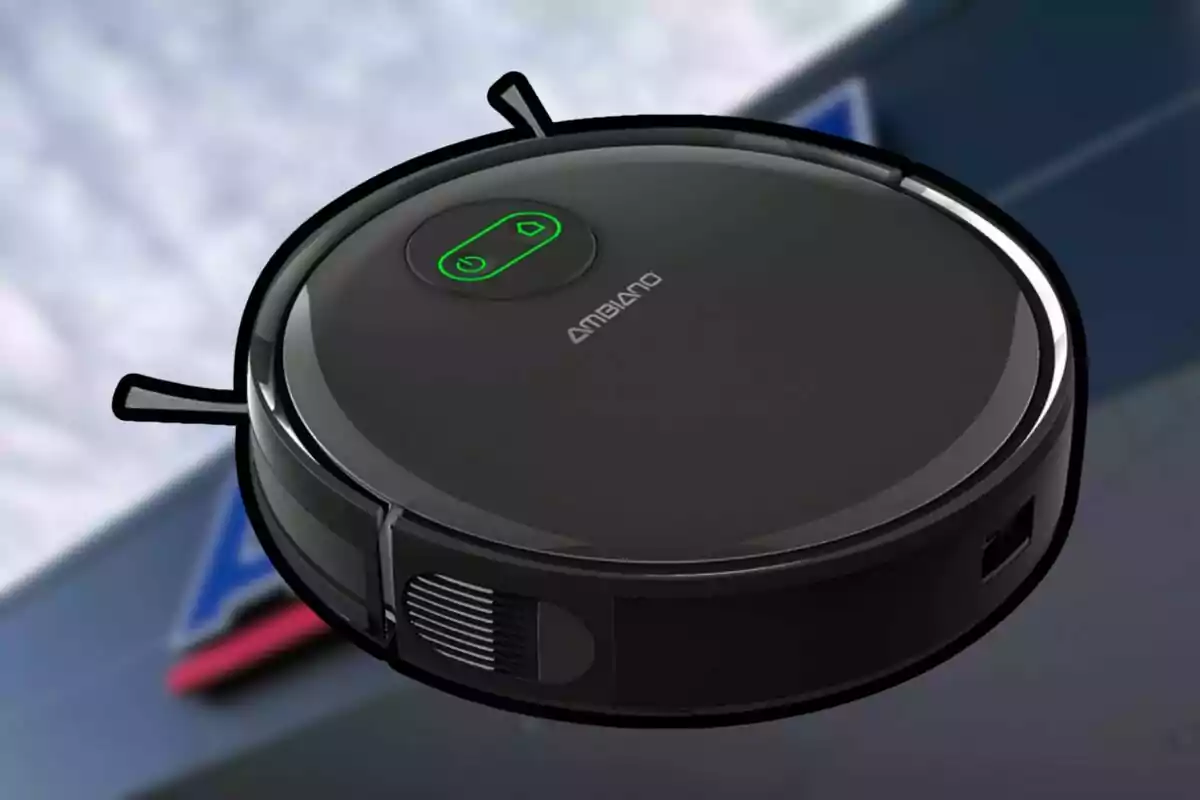 Robot aspiradora Ambiano de color negre amb botons verds sobre un fons desenfocat