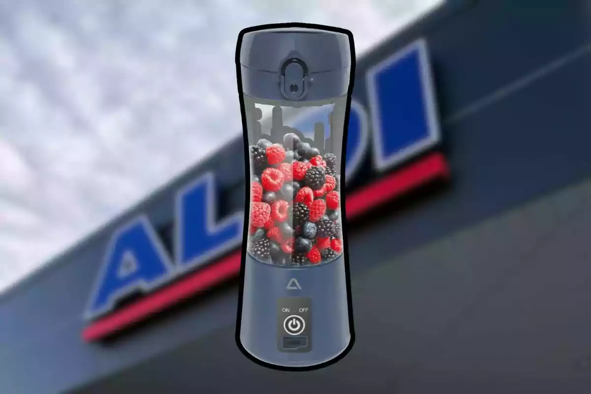 Licuadora portátil con frutos rojos y moras al frente de una tienda Aldi desenfocada Licuadora portátil con frutos rojos y moras al frente de una tienda Aldi desenfocada
