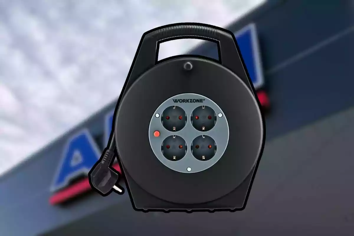 Carrete de cable eléctrico negro con cuatro enchufes y asa, marca Workzone, sobre un fondo desenfocado de una tienda. Carrete de cable eléctrico negro con cuatro enchufes y asa, marca Workzone, sobre un fondo desenfocado de una tienda.