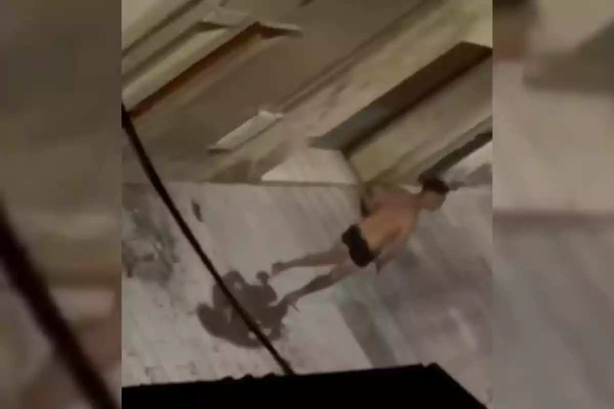 Un home sense camisa i en roba interior camina per un carrer desert durant la nit