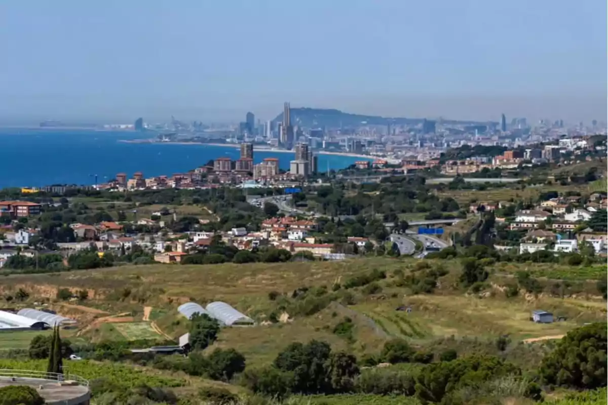 Vista panorámica de Alella, pueblo costero de Barcelona con edificios altos al fondo, el mar a la izquierda y áreas verdes y residenciales en primer plano Vista panorámica de Alella, pueblo costero de Barcelona con edificios altos al fondo, el mar a la izquierda y áreas verdes y residenciales en primer plano